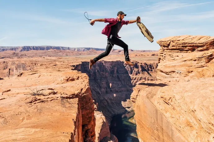 man jumping on rock formation